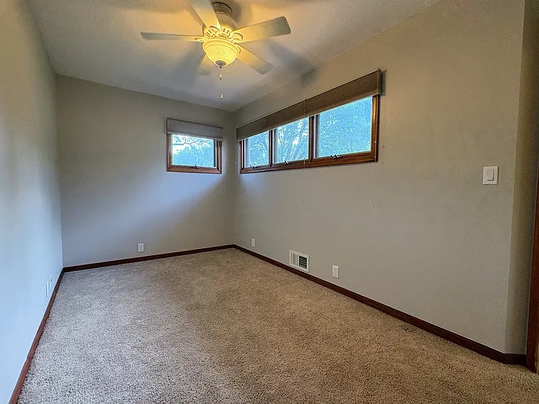 3rd Bedroom or Main Level Office. Carpeted floor. Ceiling fan. Raised awning-style windows provide privacy and invite in the sunshine.
