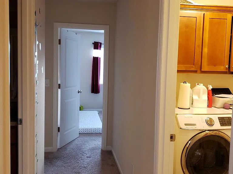 Hall walkway with laundry room on right