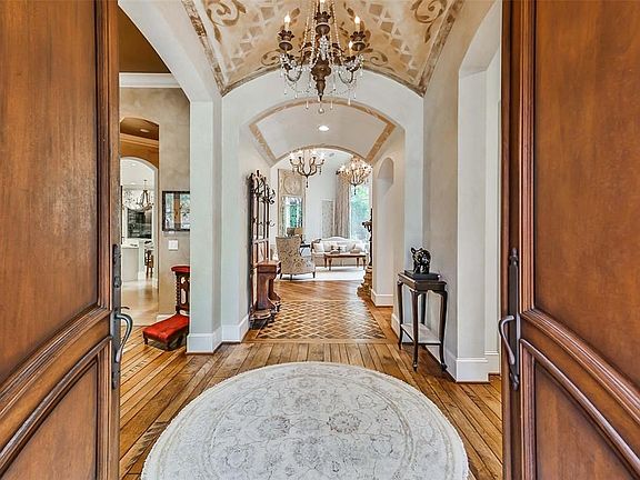 Enter this home through mahogany doors into an impressive foyer.  Note the custom painted groin vaulted ceiling and basket-weave detail on the hardwood floors.