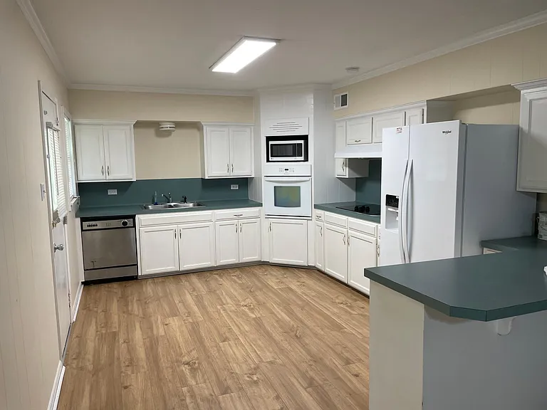 Large kitchen including built in dishwasher, cooktop and oven. In addition, a microwave and new refrigerator complete this newly refurbished kitchen.