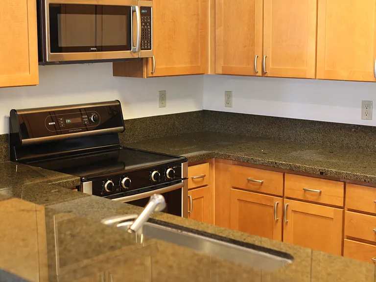 Kitchen with granite counter tops, stainless steel appliances.
