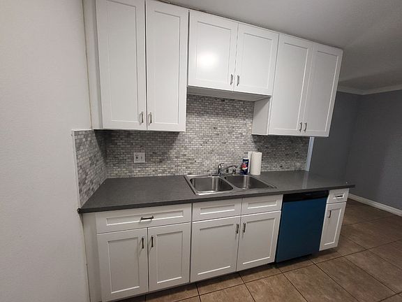 Enjoy cooking in this beautifully updated kitchen, featuring brand new, just-installed white cabinets and a brand new dishwasher. The modern look is completed with new grey countertops and a stylish tile backsplash.