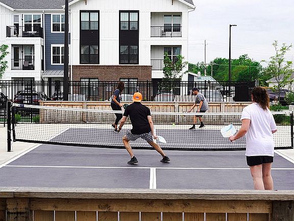 Amenities at Nese Apartments include an outdoor pickleball court.