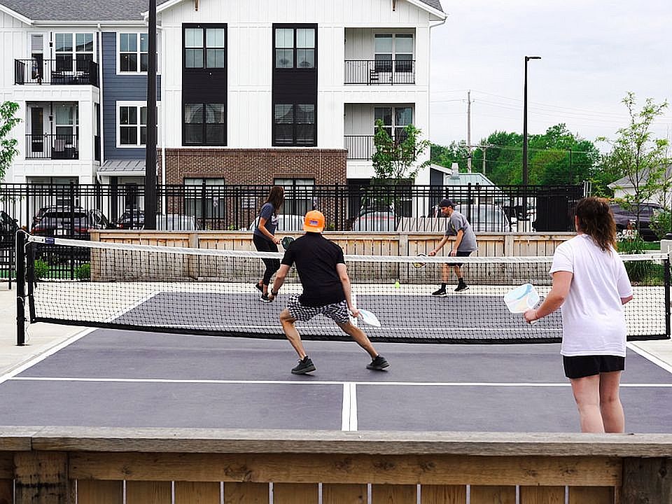 Amenities at Nese Apartments include an outdoor pickleball court.