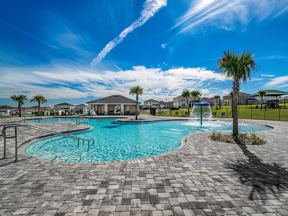 Expansive community pool with splash features and open-air seating.
