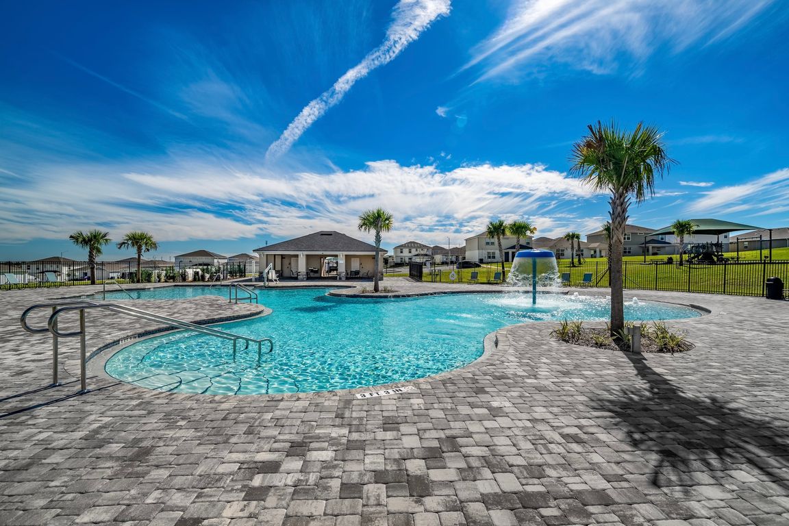 Expansive community pool with splash features and open-air seating.