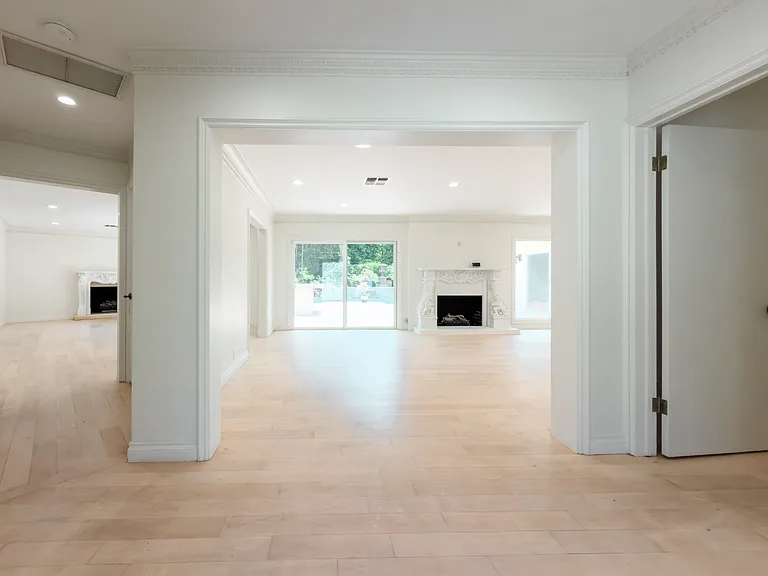 Sweeping archway leads to a light-filled living room with fireplace in this Beverly Hills luxury rental at 1094 Garden Lane, a 90210 home for rent.