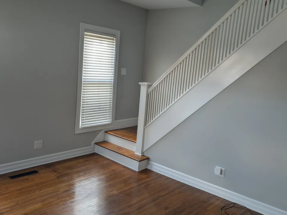 This room has been recently completely renovated with new walls, ceiling, electrical, refinished hardwood floors. The room has a ceiling fan and three windows with blinds. Painted in a light grey color. Living room size: 12 x 13