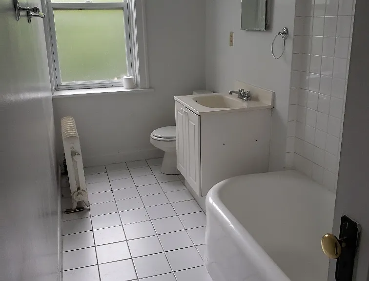 Tile full bathroom with bathtub and shower and big frosted window, freshly painted