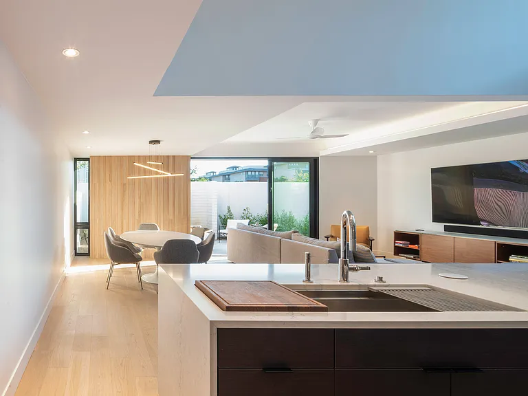 Natural light, clean architectural lines, warm flooring, and open sightlines create a refined modern living environment that feels both elevated and comfortable.