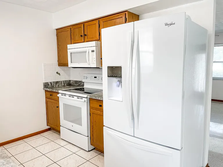 Recently purchased refrigerator with icemaker, clean range and microwave.
