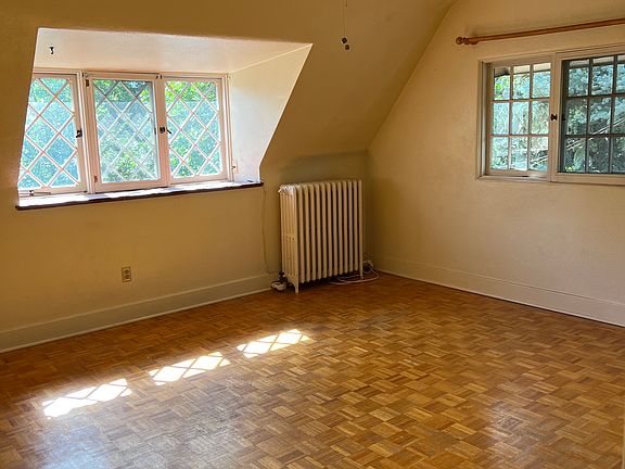 Spacious bedroom with six cottage style windows for superb natural light. Ceiling fan, and real wood parquet flooring.