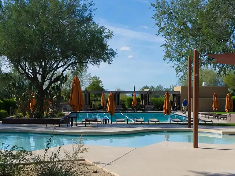 Refreshing Outdoor Pool Area with Cabanas and Umbrella-Covered Seating