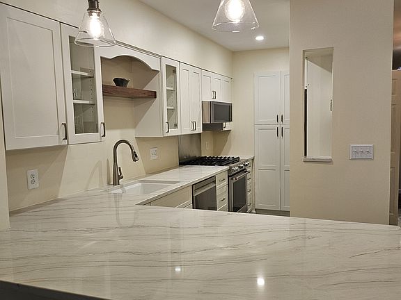 Newly renovated kitchen includes pots, pans, and cookware.