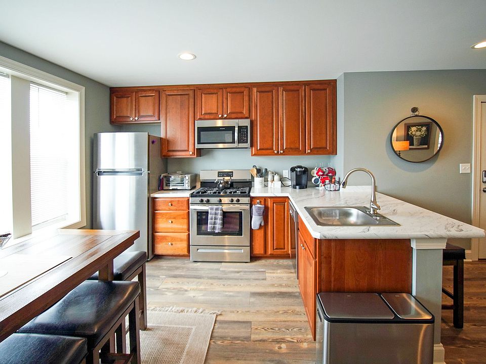 EAT-IN KITCHEN WITH BREAKFAST BAR, STAINLESS STEEL APPLIANCES (INCLUDING DISHWASHER), AMPLE CUPBOARD SPACE AND TONS OF NATURAL LIGHT