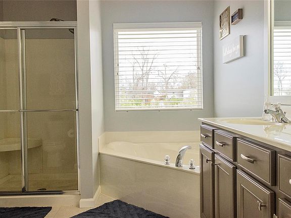The master bath has a custom adult height, double-wide vanity, shower with built-in seat, and separate soaking tub.