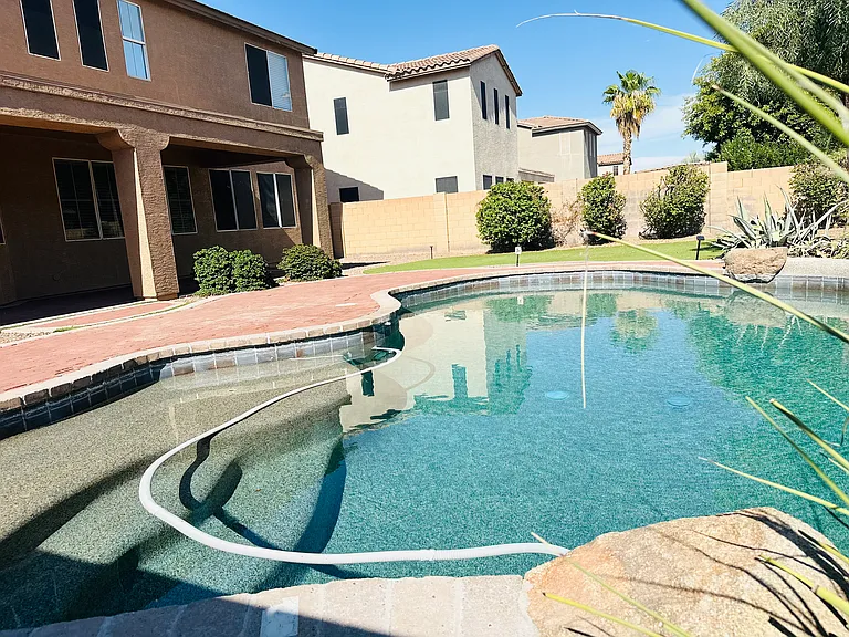 Private PebbleTec pool with a water feature and extended paver patio_professional pool service is included in the rent.