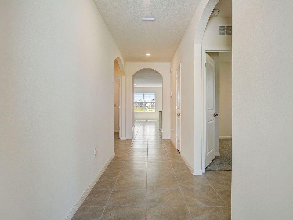 Entry Hallwa :Welcoming tiled hallway with elegant archways leading to the open-concept living area _ bright, spacious, and freshly painted.