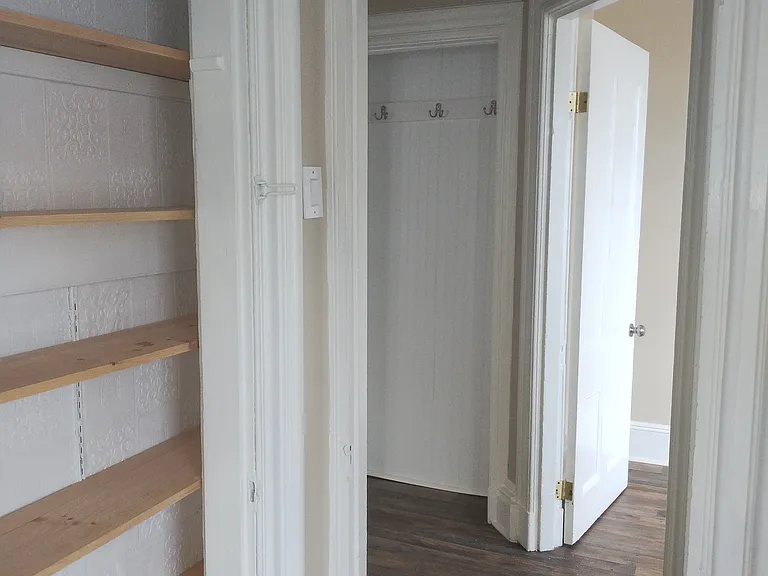 View from kitchen. Pantry to left. Spare room through door on right. Center hall nook with coat hooks.