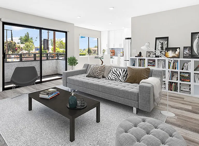 Large hardwood floored living rooms with can lights and view of balcony.
