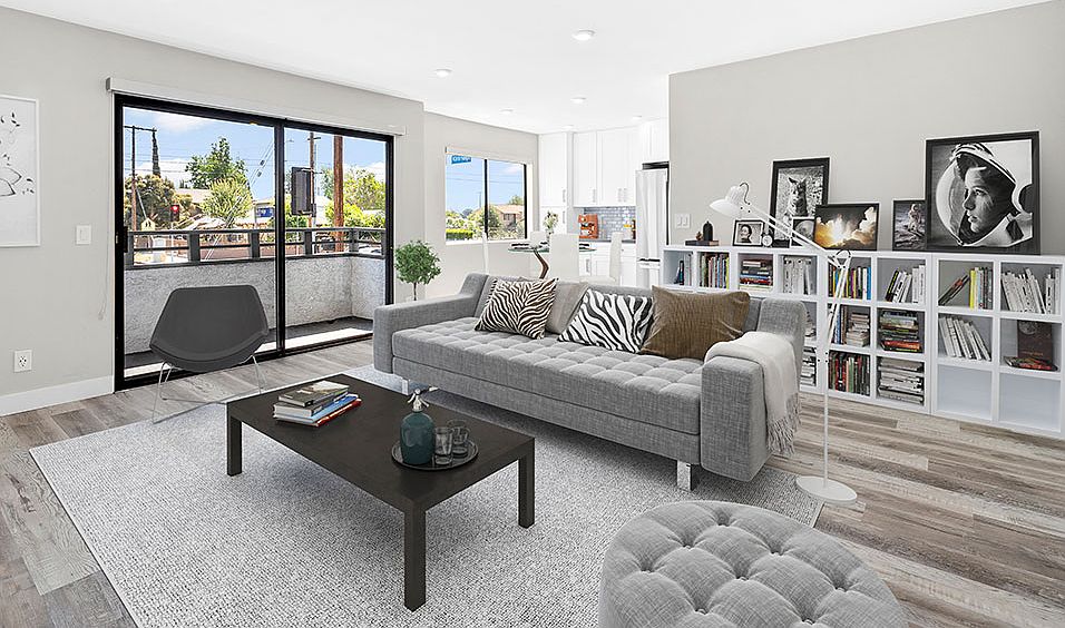 Large hardwood floored living rooms with can lights and view of balcony.
