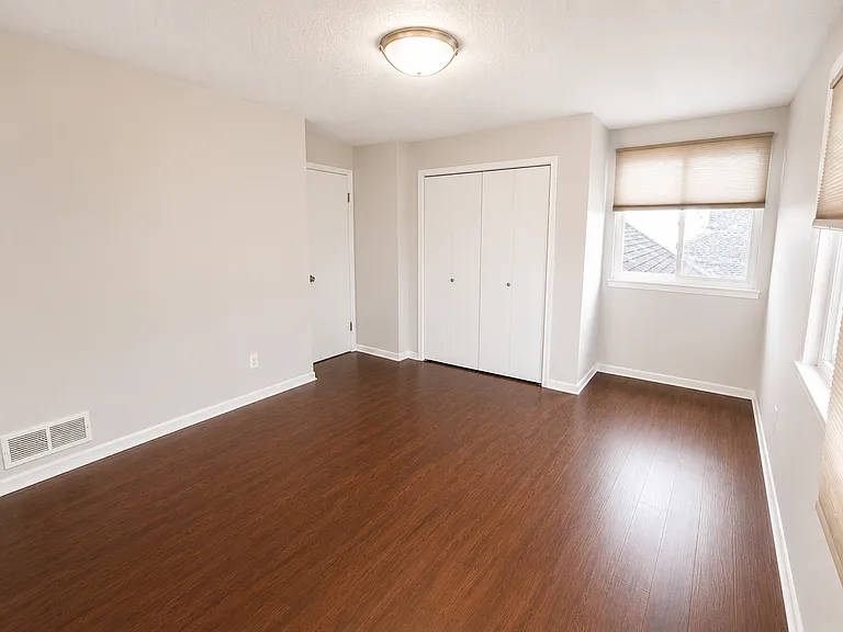 Second Bedroom - 
Bright and spacious second bedroom featuring rich hardwood-style flooring, generous closet space, and abundant natural light; ideal as a guest room, home office, or additional bedroom.