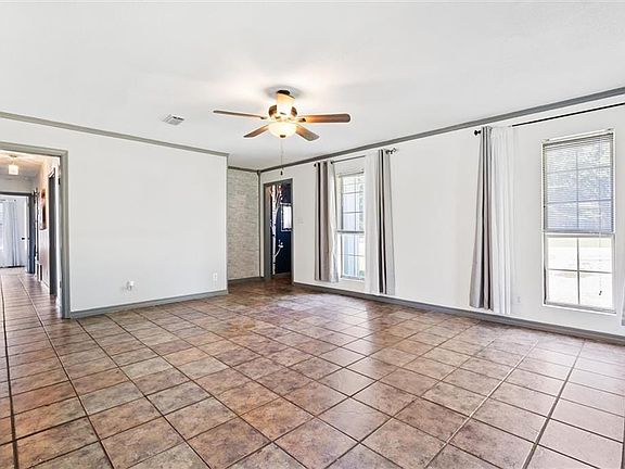 Tiled spare room with crown molding and ceiling fan