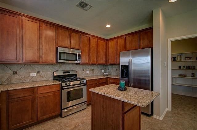 Kitchen features stainless steel appliances and walk-in pantry