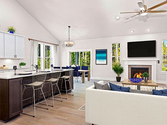 Kitchen and family room with fireplace and vaulted ceiling in a DRB Homes Latitude home.