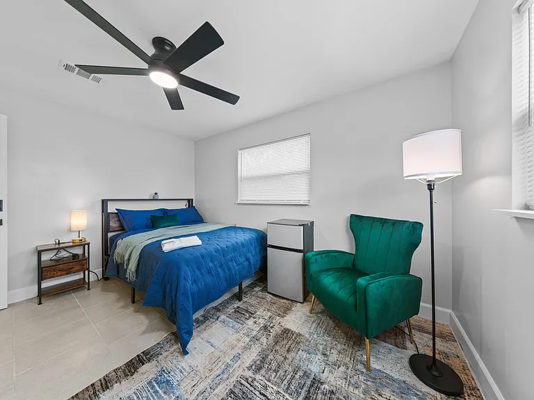 Ceiling fan, floor lamp, accent armchair a calm, quiet room ready for move-in day.