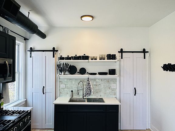 Bright kitchen with modern cabinetry and fully stocked open shelving