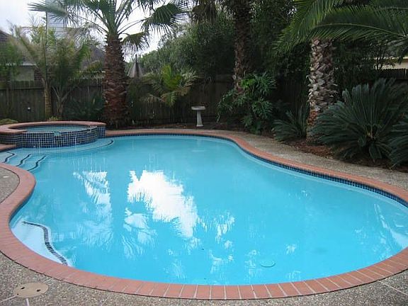 Large heated pool and spa with tropical foliage