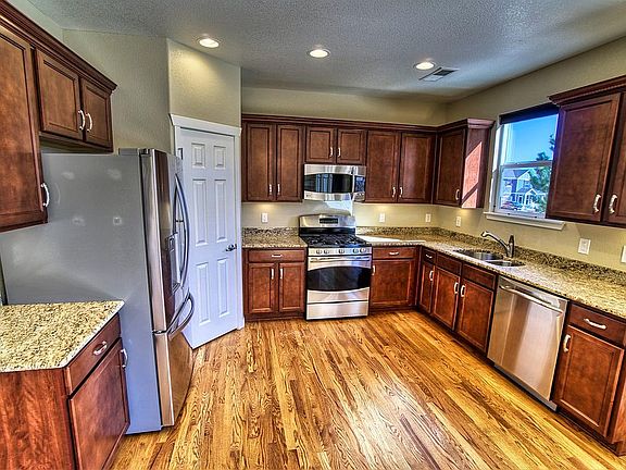 Main level - kitchen w/pantry, like-new stainless steel appliances, under-cabinet lighting, hardwood floors, and granite counter tops (14' x 11').