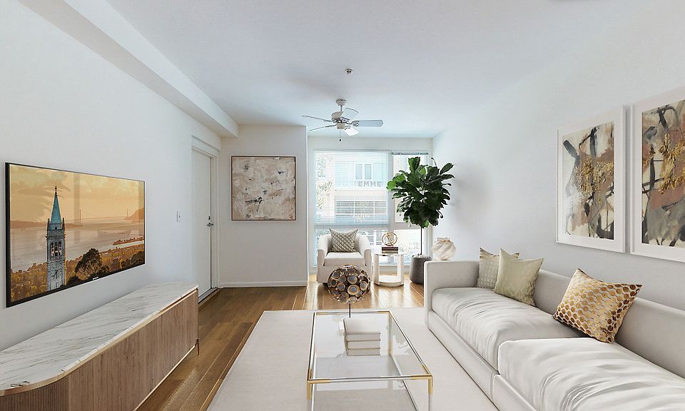 Staged living room with hardwood style vinyl flooring, ceiling fan, and large window.