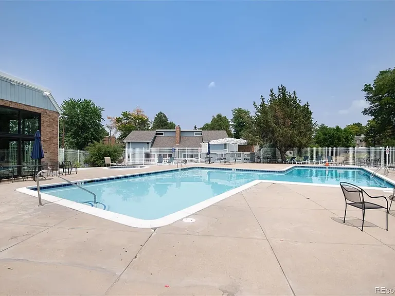 Community outdoor pools with chairs, tables, and umbrellas provided