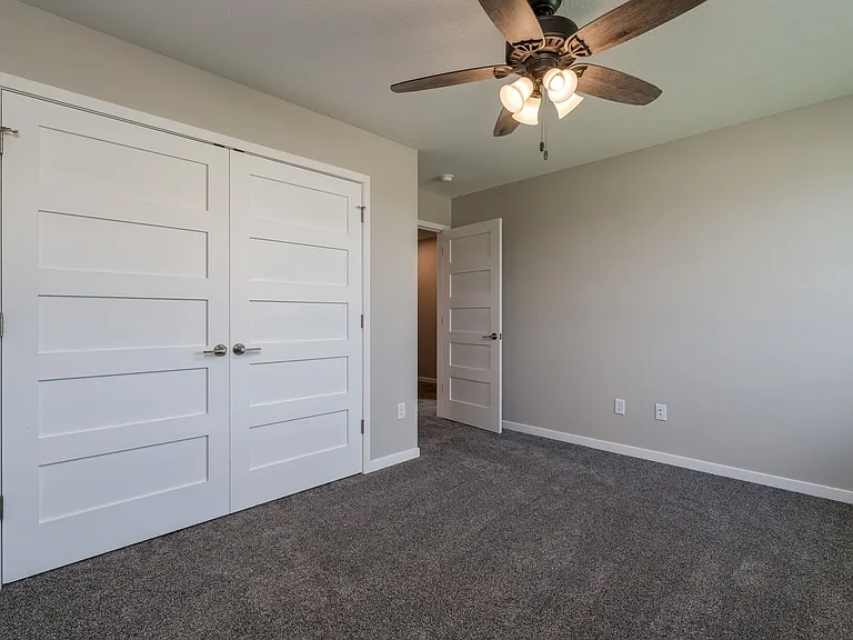 Large secondary bedrooms with double closet doors and ceiling fans.
