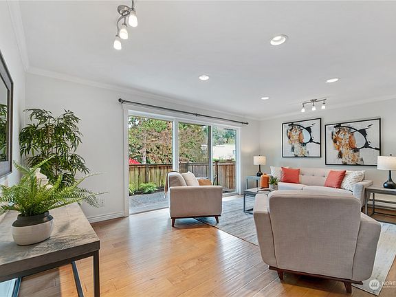 The living room features gorgeous hardwood floors, crown molding, updated lighting, and abundant natural light. Right off the living room is a sliding glass door to your private fenced in garden and patio.>