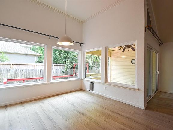 Sizeable formal dining room with wall of windows overlooking deck and backyard.