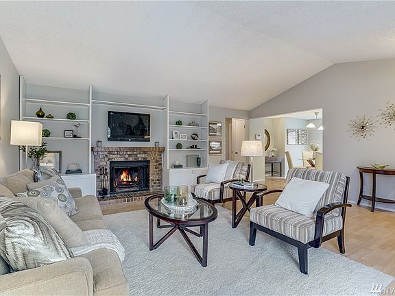 Welcome to your large and well appointed living room. Cozy up to this classic brick, wood burning fireplace. Vaulted ceilings and natural light throughout. Entire Home has all new interior paint. Easy to clean and care for laminate flooring throughout. 