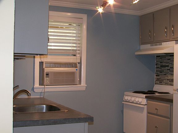 Efficient kitchen, concrete counters, glass tile backspash