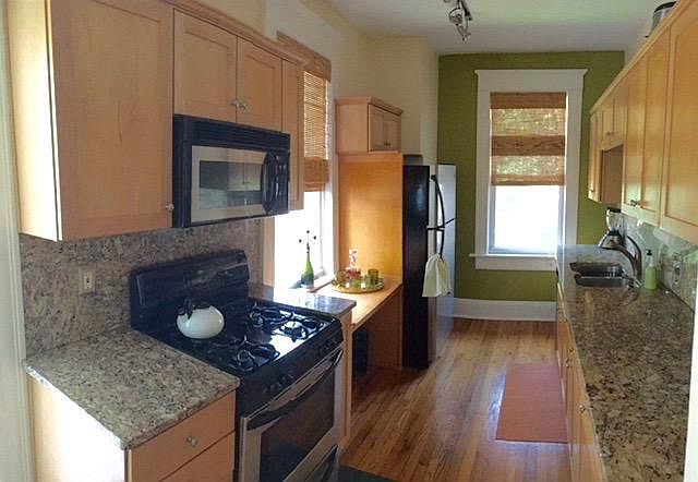 Large galley kitchen with modern appliances and gas range.