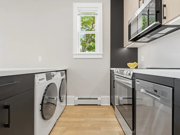 Facing the living area, you can see the undercounter washer and dryer conveniently located out of sight in the contemporary kitchen.