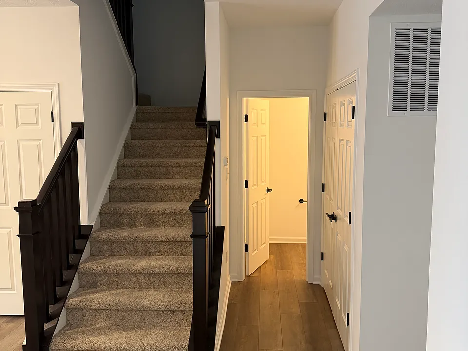 Stairs to 2nd floor. Utility closet on right, half bath at end of corridor