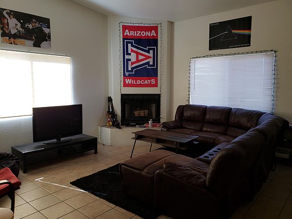 Large living room with tall ceilings and wood-burning fireplace