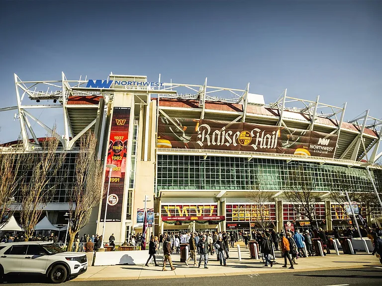 Exterior street view showing a large building facade with prominent signage and a wide pedestrian entry area.