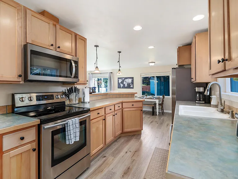 Open concept kitchen a bar with all stainless steel appliances and ample cabinet space