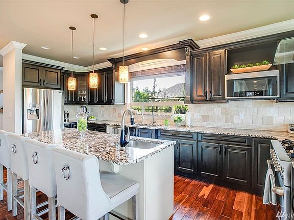 Bright chef's kitchen off the great room with pro-series oven, high output fan, second prep-sink, BIG walk-in pantry, multiple sitting areas and more.