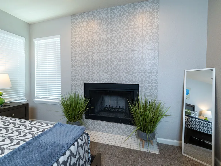 Primary bedroom with king size bed, dresser and fireplace.