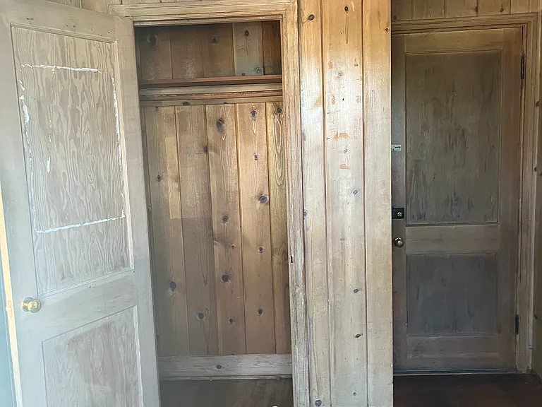 Closet in bedroom knotty wood walls.