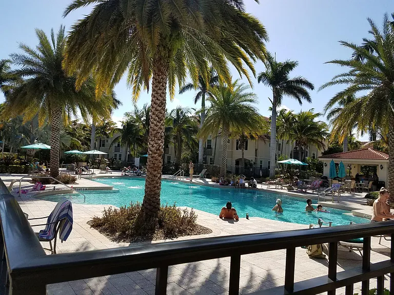 There are various tables and lounge chairs around both pools.